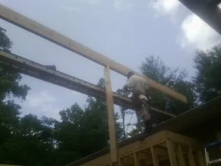 Carpenter setting a ridge beam over a new addition frame — Ice Dam Removal by Roofing Brothers in Sagamore