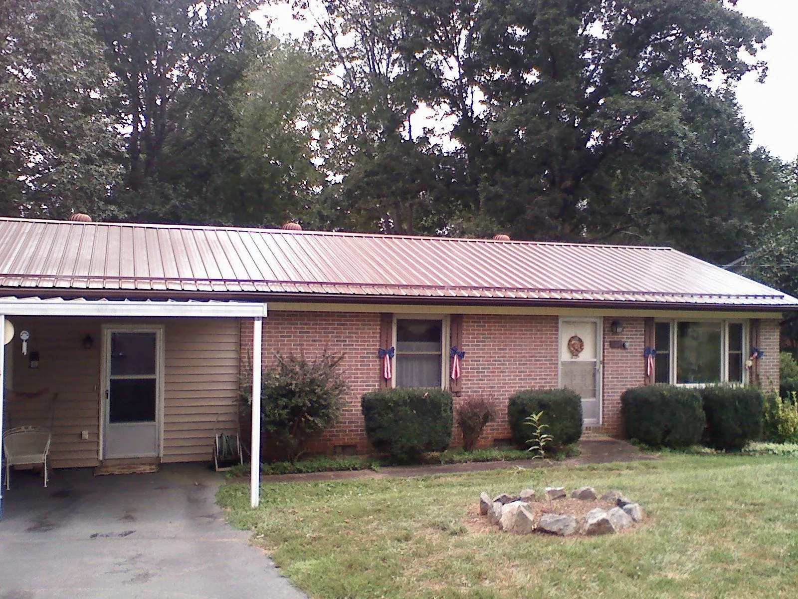 Bronze metal roof and carport on a brick ranch home — Roof Repair work by our crew in Sagamore